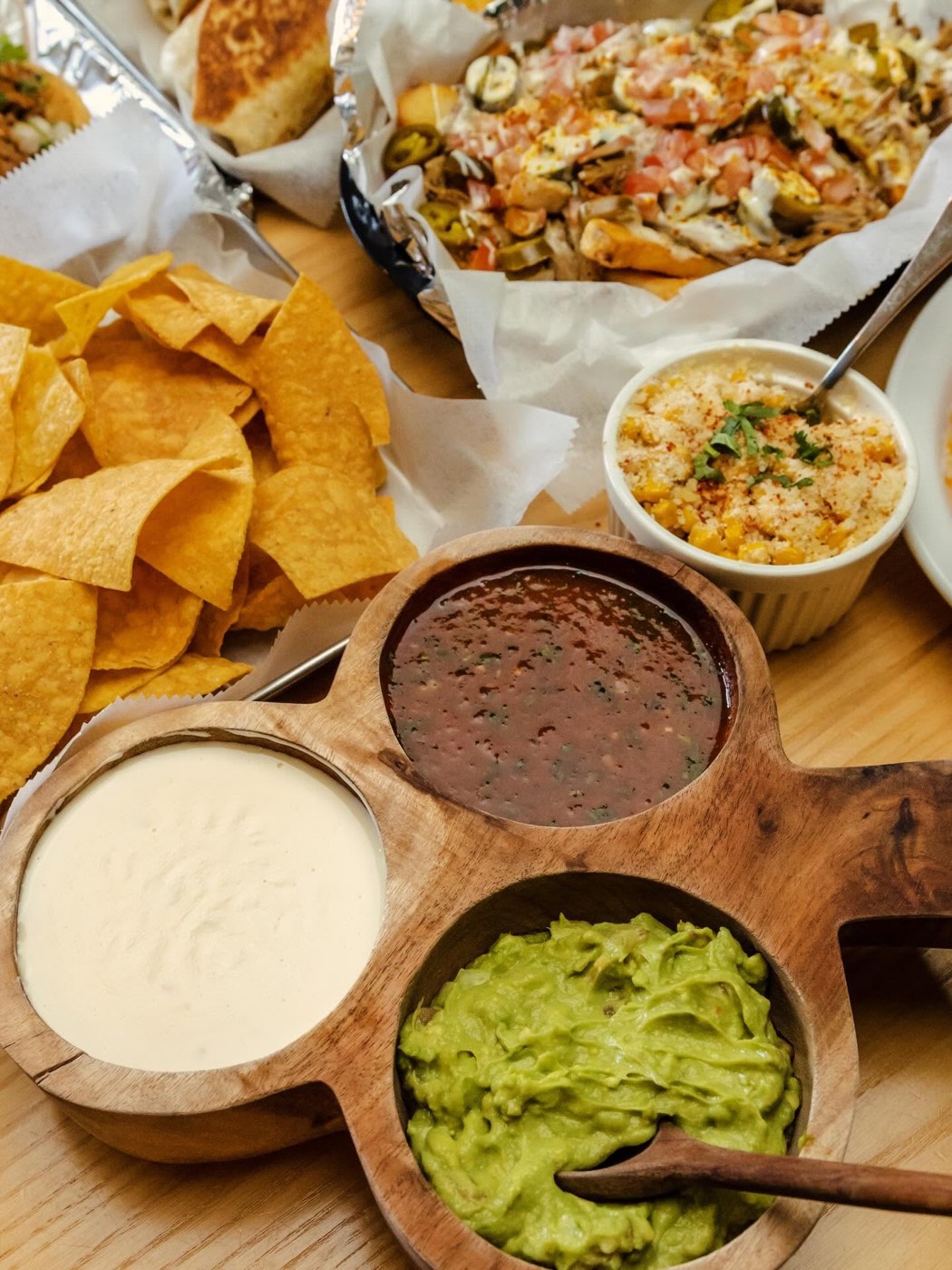 Queso, salsa roja and guacamole trio with tortilla chips and elote