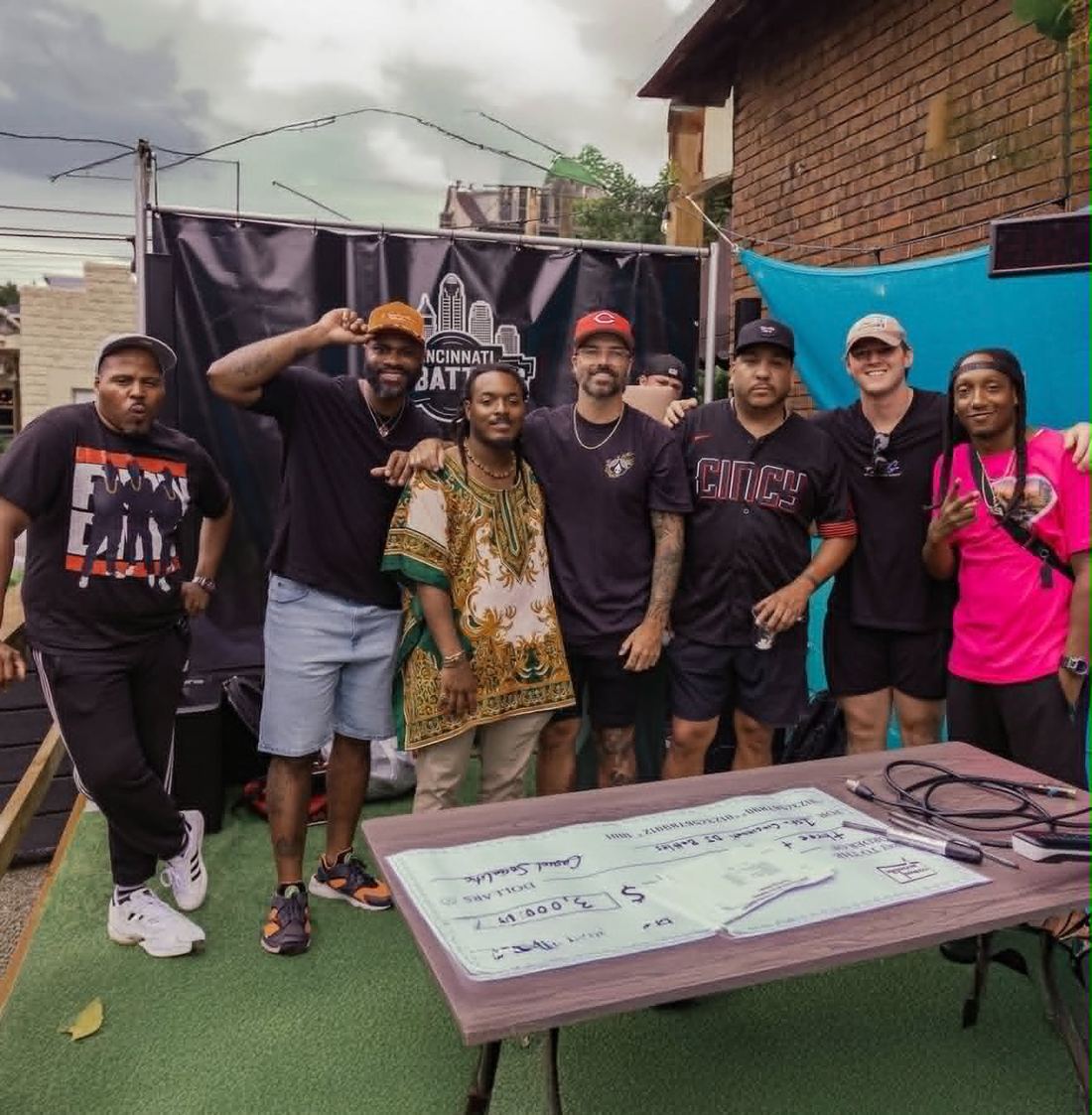 Winning DJs and organizers posing with a $3,000 prize check at Cincinnati DJ Battles
